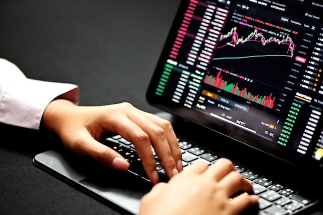 Trader typing on a laptop showing market data